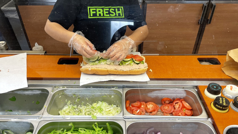 Subway employee preparing a sandwich