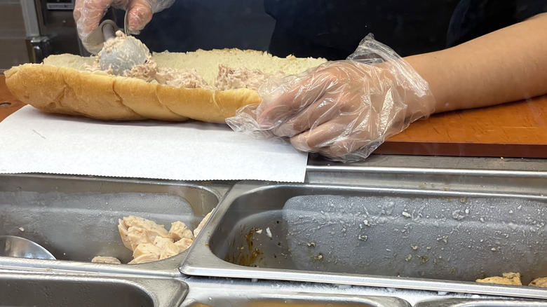 Subway employee making tuna sub