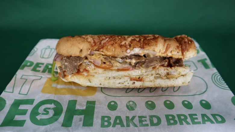 six-inch Subway sub on wrapper green background