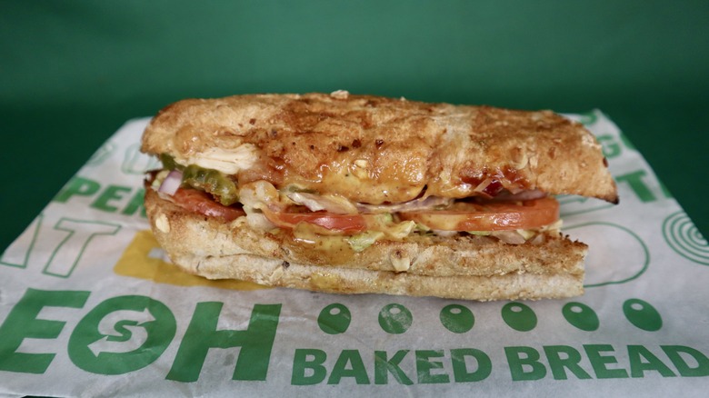 six-inch Subway sub on wrapper green background