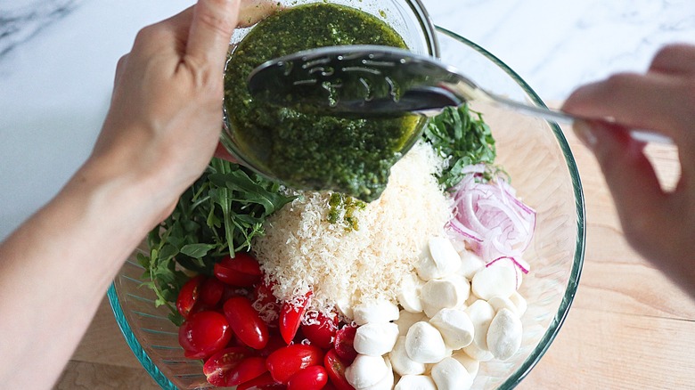 pouring pesto into bowl