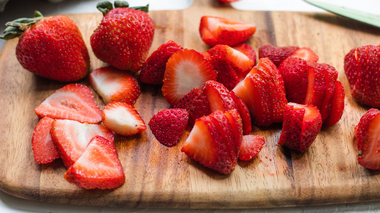 sliced strawberries on cutting board