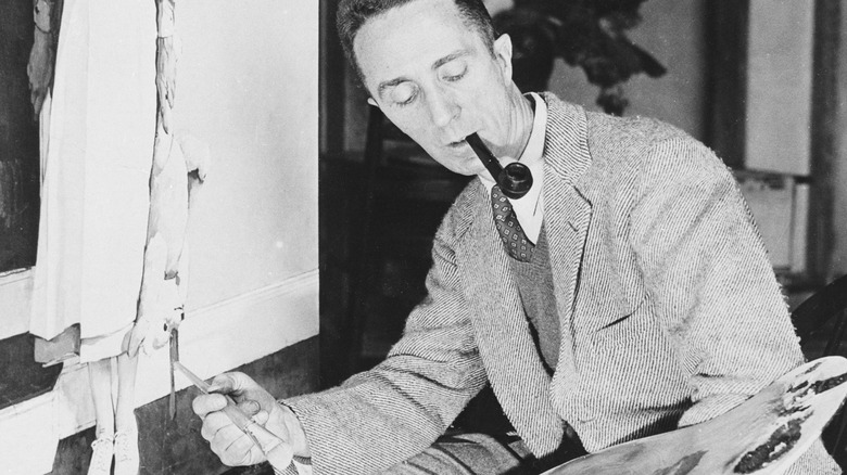 Norman Rockwell smokes pipe while painting