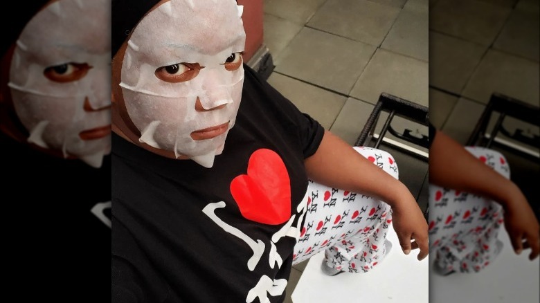 Sunny Anderson wearing pajamas and a face mask.