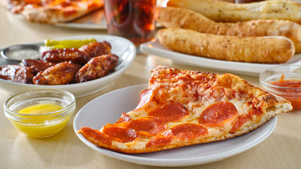 Slice of pizza on plate with wings