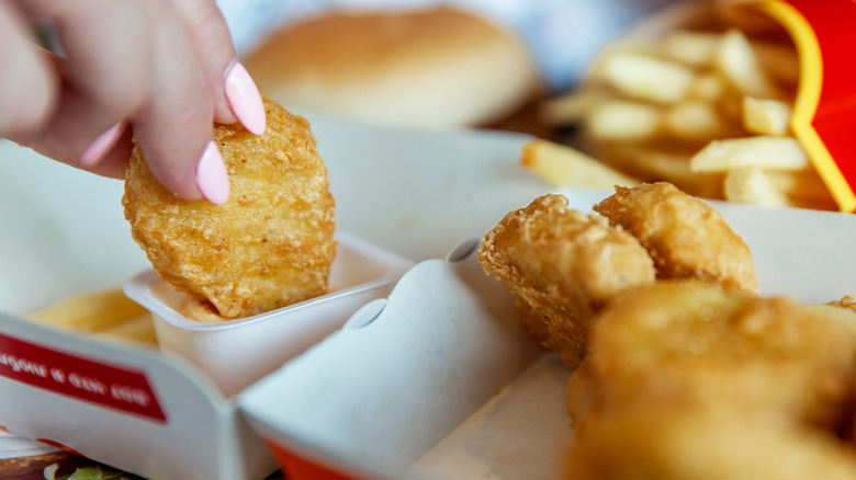 A McDonald's Chicken nugget being dunked in sauce