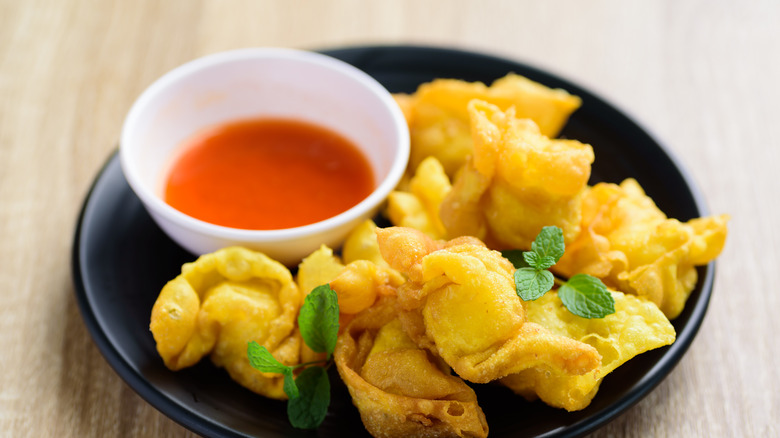 Plate of fried wontons with sweet spicy dipping sauce