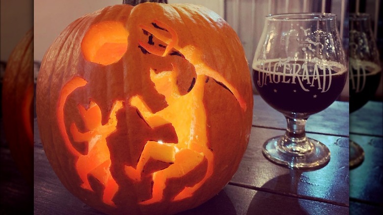 A pumpkin with the devil and ghoul dancing carved on it