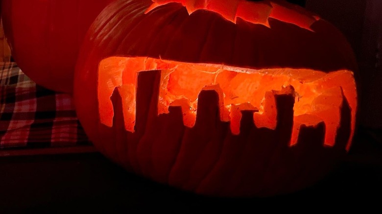 A pumpkin with a city skyline carved on it