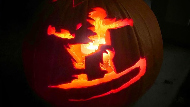 A pumpkin with a snowboarder designed carved into it