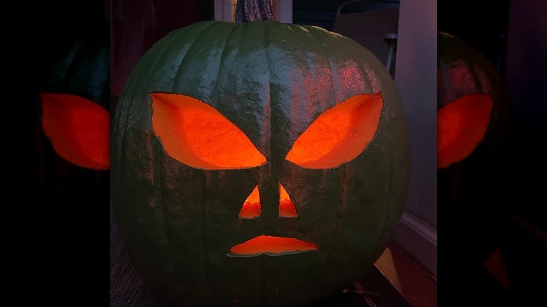 A green pumpkin with an alien face