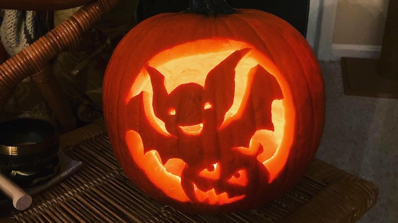 A pumpkin with a cartoon bat and pumpkin carved on it