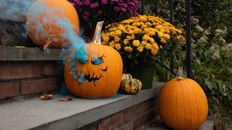 A jack-o-lantern with blue smoke pouring out