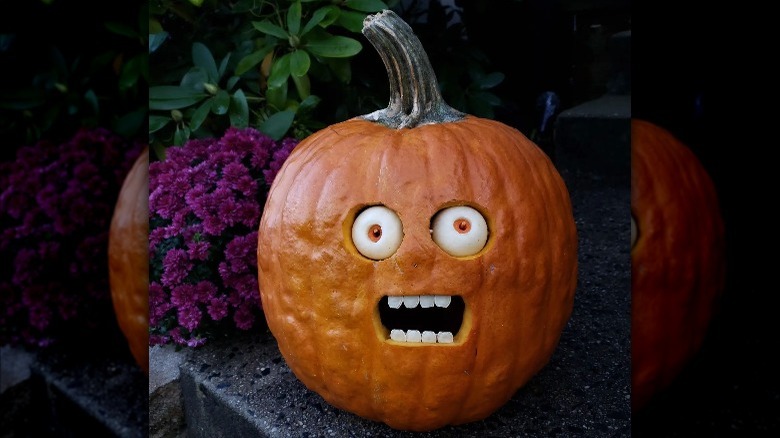 A pumpkin with smaller pumpkins for eyes and pumpkin seed teeth