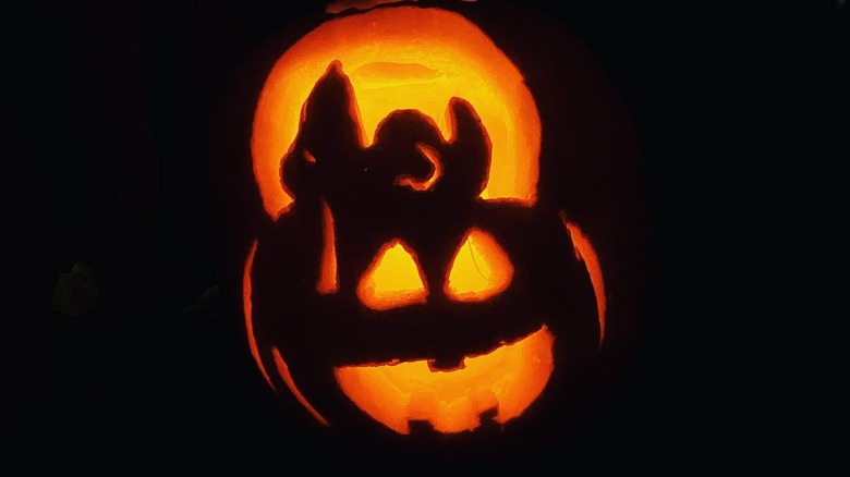 A pumpkin carved with Snoopy on a big pumpkin