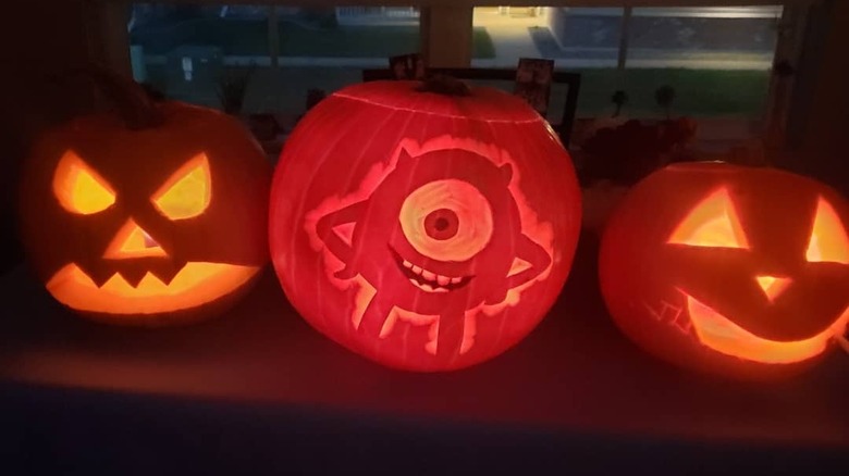 A pumpkin with a carving of Mike Wazowski