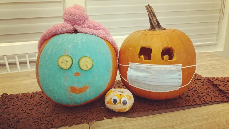 Two pumpkins wearing face masks