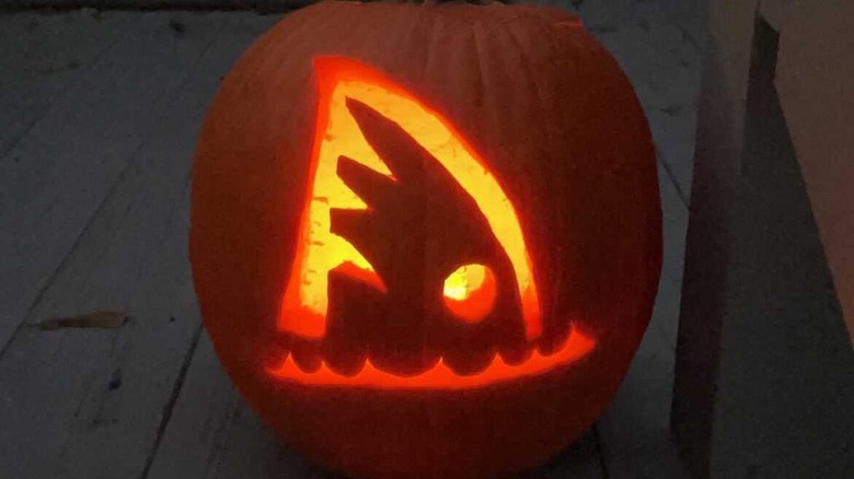 A pumpkin with a shark's fin carved on it