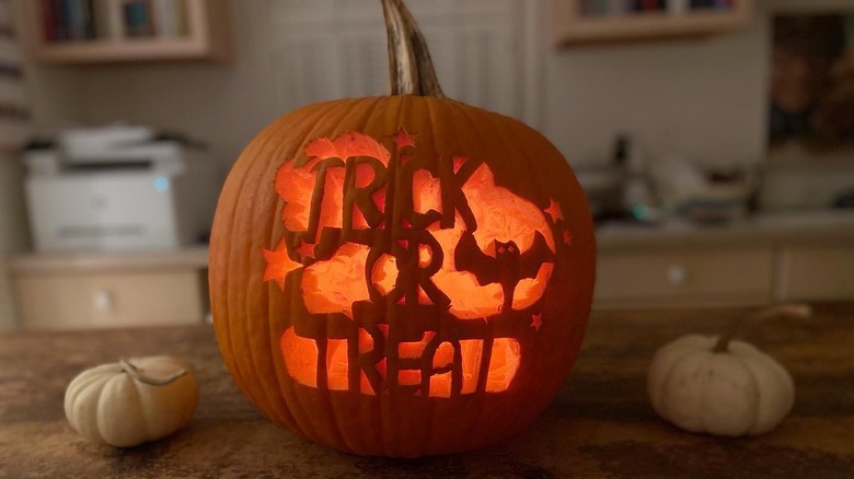 A pumpkin with the words "trick or treat" carved on it