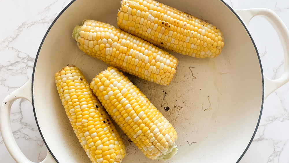 cooking corn cobs in a large pot for this super simple elote