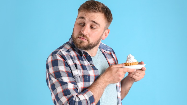 A man hoarding a dessert