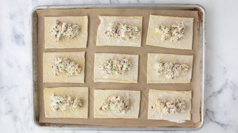 pastry rectangles with cheese mixture dollop on baking sheet