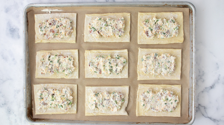 pastry rectangles with cheese mixture on baking sheet