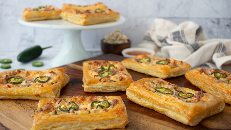 baked cheese and jalapeño tarts on wooden board