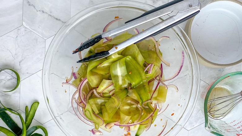 cucumber onion salad with tongs