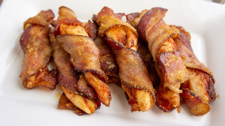 bacon wrapped chicken tenders on a white plate