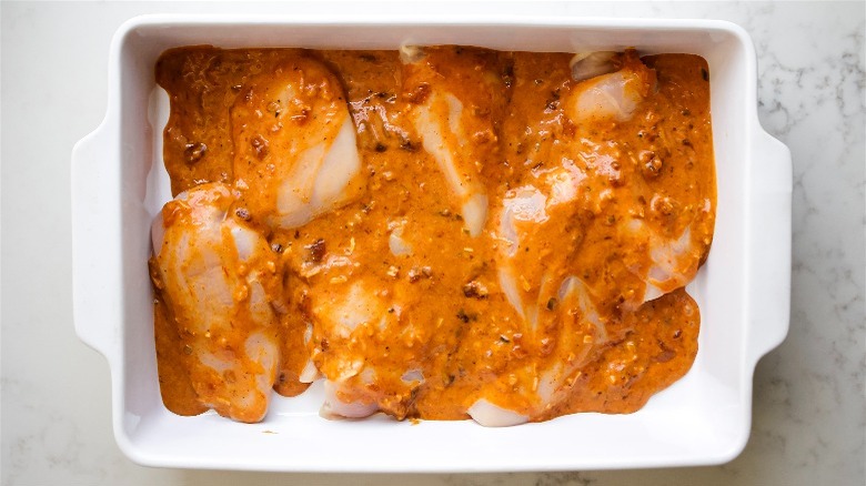 raw chicken in pan with sauce