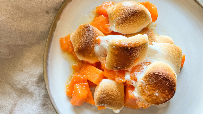 Yams with marshmallows sitting on a plate