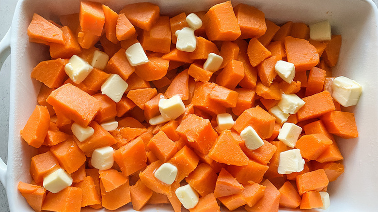 Cubed yams and butter in a baking dish