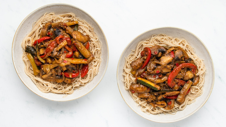 Two bowls of noodles and stir-fry veg