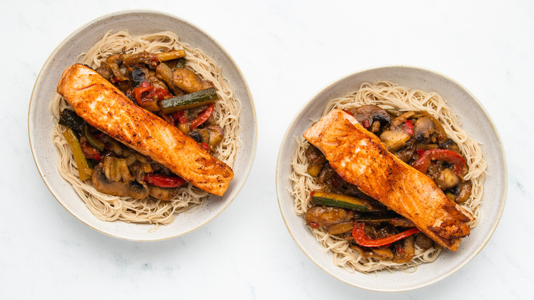 Two bowls of salmon stir-fry