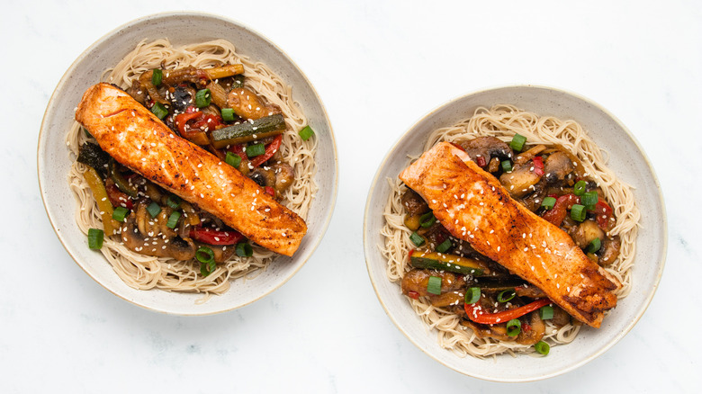 Two bowls of salmon stir-fry