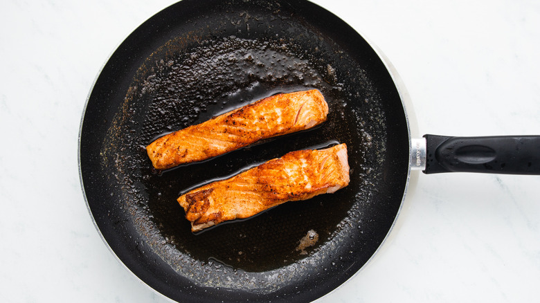 Salmon frying in pan