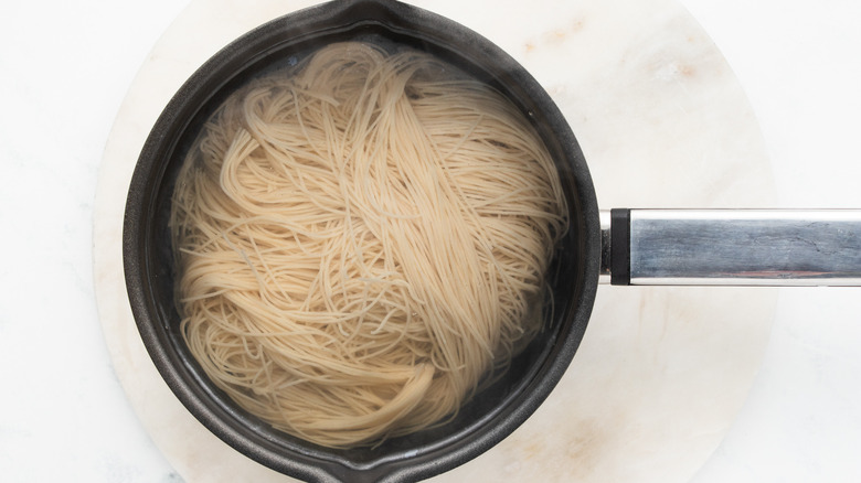 Noodles soaking in pan of water