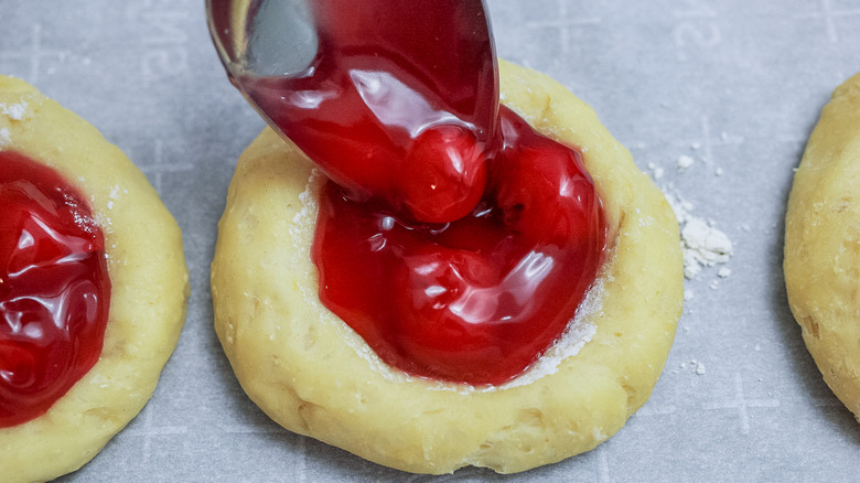 spooning pie filling onto dough