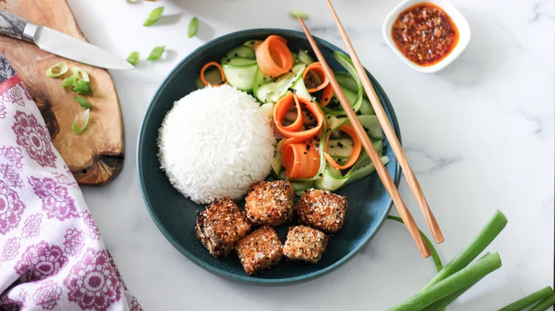 Crispy cubes, rice, pickled veg, chopsticks