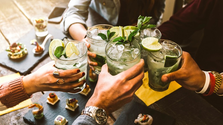 young people toasting with mojitos