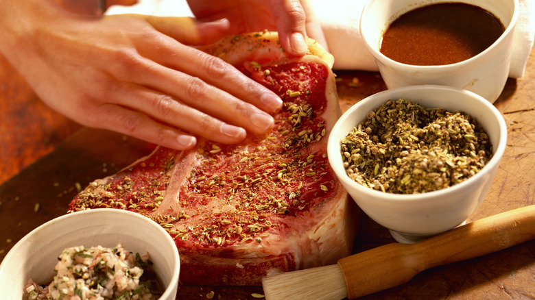 prepping t-bone steak to cook