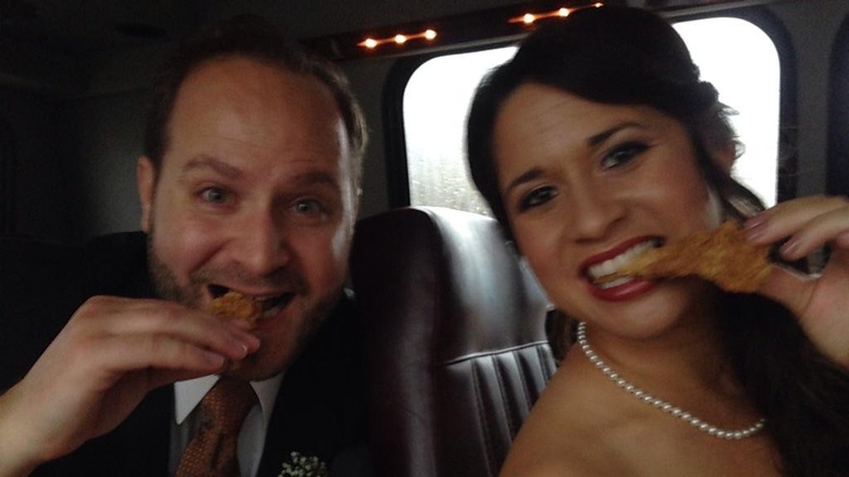 Groom and bride eating Raising Cane's after wedding