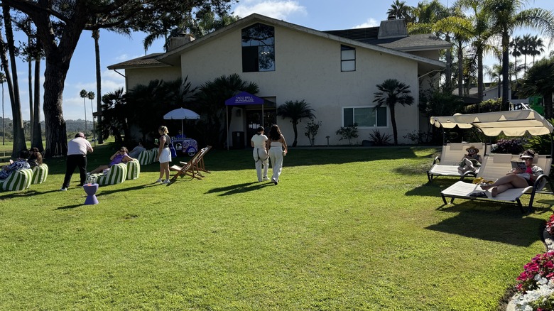 guests walk towards Taco Bell Cantinas hotel, lounge on chairs