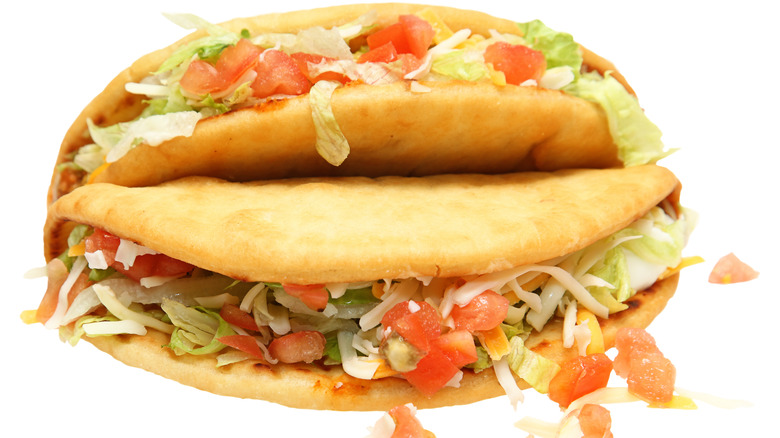 Two stacked chalupas with toppings spilling out