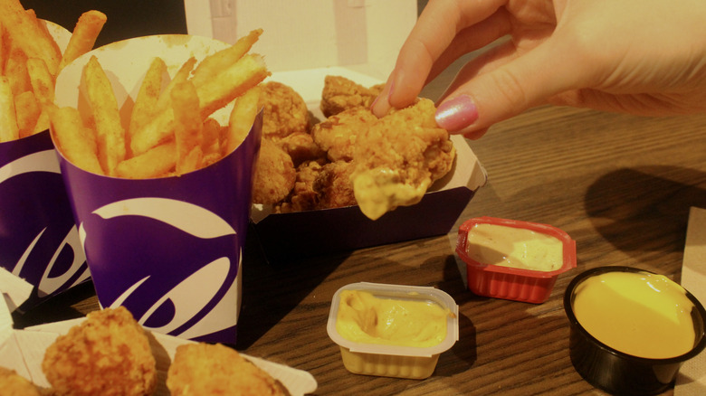 Hand dipping Taco Bell chicken nugget