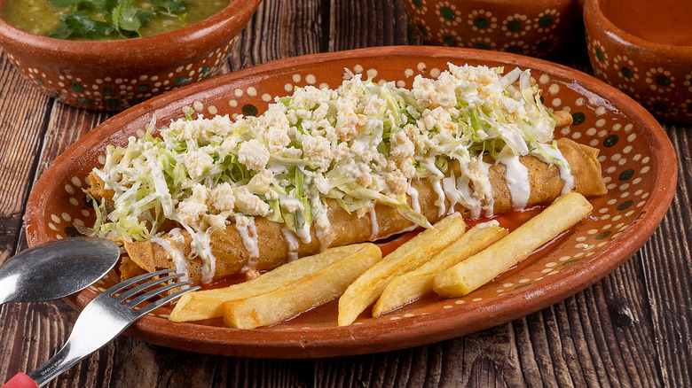 flautas topped with lettuce and sour cream