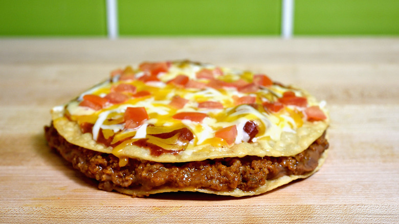 Taco Bell Mexican Pizza on wood counter green tile background