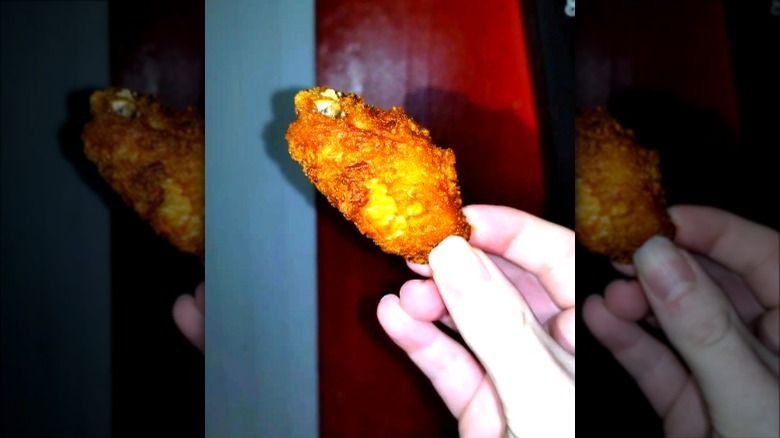 Hand holding Taco Bell chicken wing