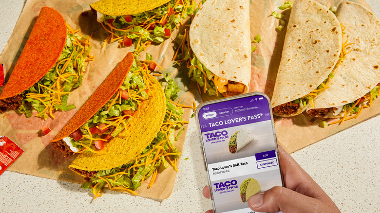 "Taco lover's pass" on phone held over tacos